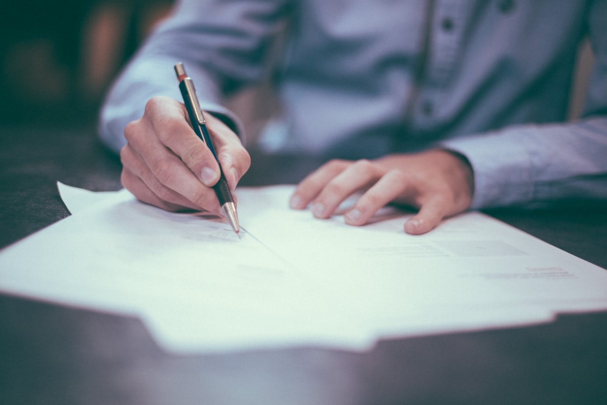 Persona firmando documentos legales - multas SUNAT